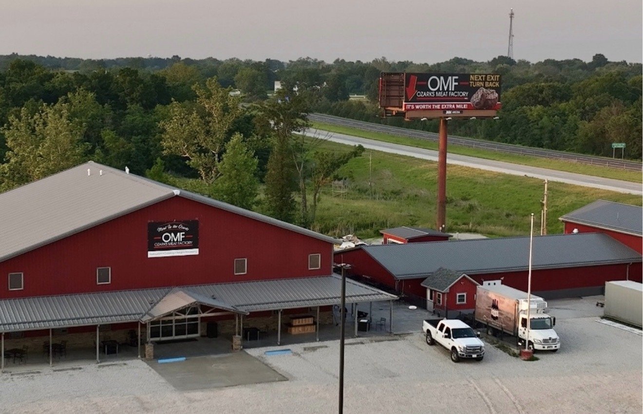 Ozarks Meat Factory facility in Fulton, MO with the OMF billboard along the highway
